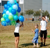 Rozdawanie balonów helowych na pikniku firmowym.