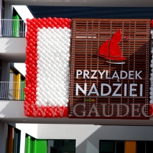 Logo szpitala odsłonięte przez rozsunięte ściany balonowe.